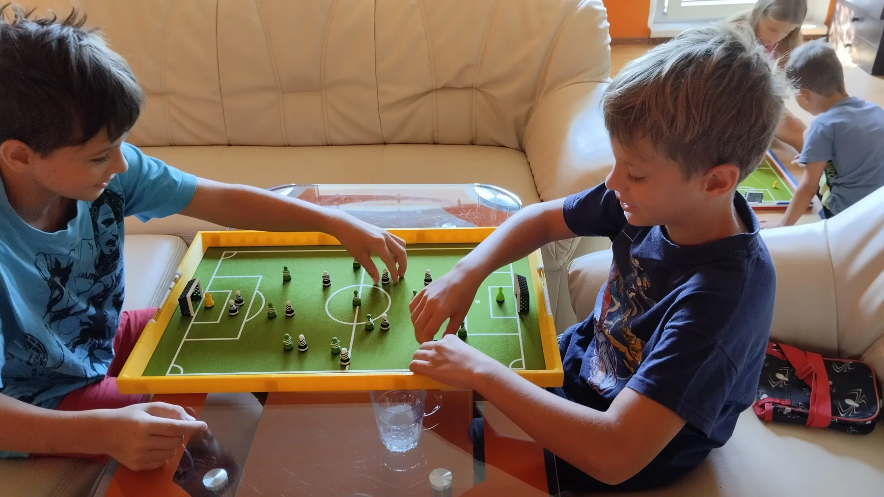 Zwei Kinder spielen Footballec im Wohnzimmer